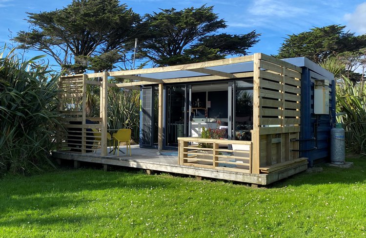 Sunset Studio Apartment Pod. The absolute beach front location is simply sensational, drift off to sleep listening to the pounding of the surf. Set within lush Harakeke gardens you’ll feel private and snug.