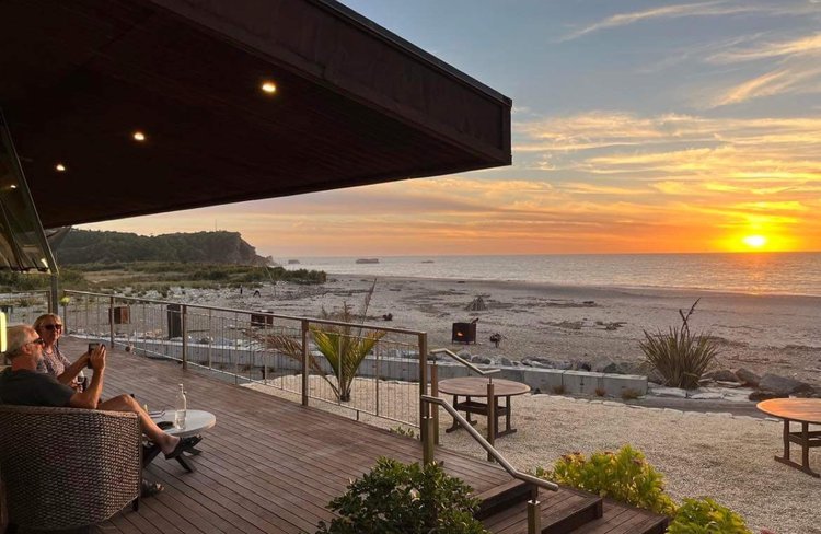 Friends enjoying a drink outside "On The Beach" Restaurant & Bar at The Retreat.