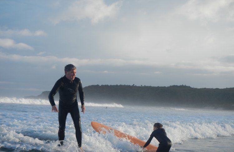 father and daughter surfing together