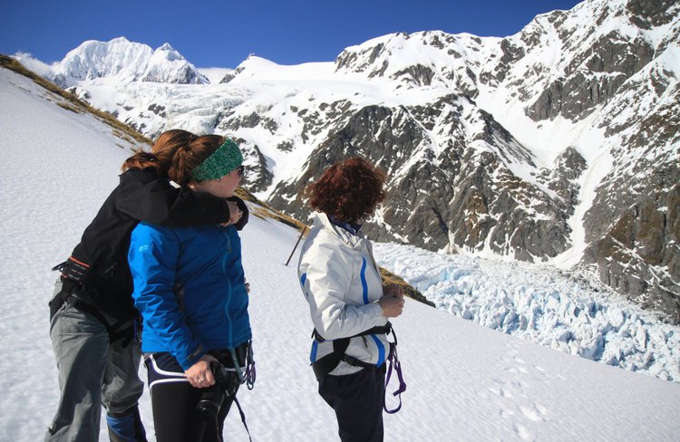 In awe looking back at Fox Glacier, Mount Tasman and surrounding mountains while ascending to Chancellor Dome in spring