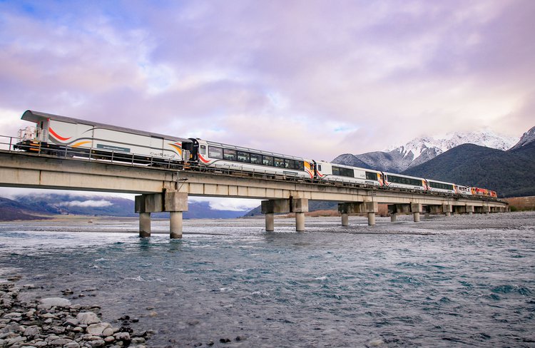 TranzAlpine train crossing a wintry Waimakariri River high in the Southern Alps near Cass.